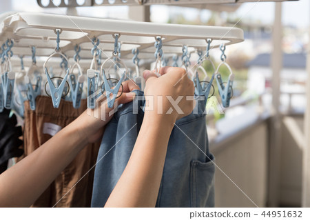 A woman hanging up the laundry 44951632