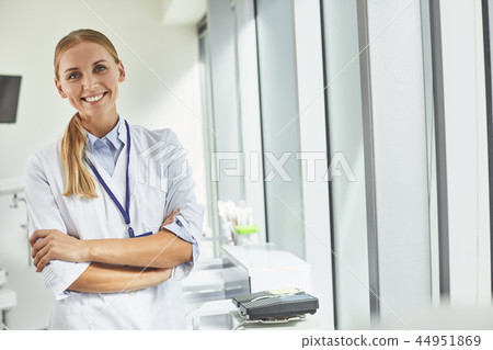 Smiling female doctor standing in medical office Smiling female doctor standing in medical office 44951869
