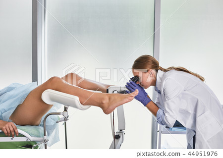 Highly qualified doctor doing gynecological examination of female patient 44951976