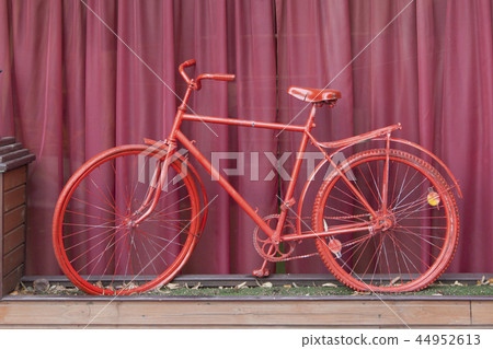 Red bicycle and a background of a fandango color. 44952613
