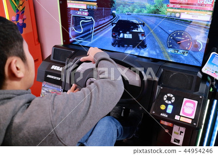 Boy enjoying car racing game in game center 44954246