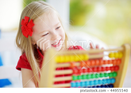 Cute little girl playing with abacus at home. Smart child learning to count. Cute little girl playing with abacus at home. Smart child learning to count. 44955540