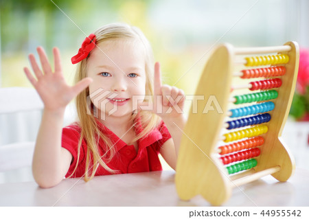 Cute little girl playing with abacus at home. Smart child learning to count. Cute little girl playing with abacus at home. Smart child learning to count. 44955542