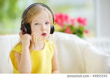 Cute girl wearing huge wireless headphones Cute girl wearing huge wireless headphones 44955545