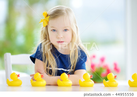 Cute little girl playing with rubber ducklings at home Cute little girl playing with rubber ducklings at home 44955550