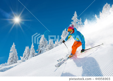 Skier skiing downhill in high mountains 44956903