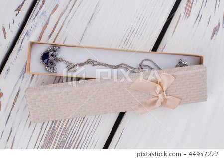 Gift box with necklace on wooden background. 44957222