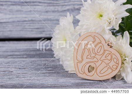 Bouquet of flowers and wooden heart. 44957703
