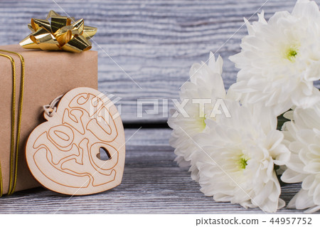 Gift, flowers and wooden heart. Gift, flowers and wooden heart. 44957752