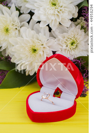 Engagement ring in red box and flowers. 44958294