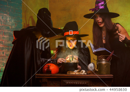 Picture of three witches in hats and dresses preparing poison on cauldron 44958630