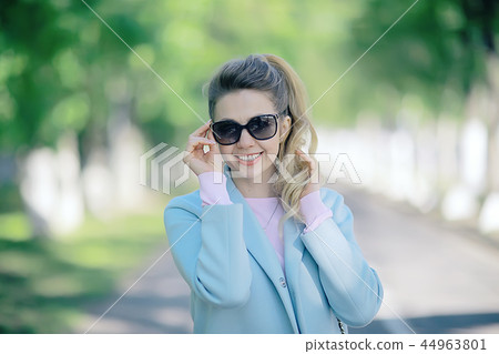 portrait of a european beautiful female model wearing sunglasses / girl outdoors walking, happy cheerful girl wearing glasses portrait of a european beautiful female model wearing sunglasses / girl outdoors walking, happy cheerful girl wearing glasses 44963801