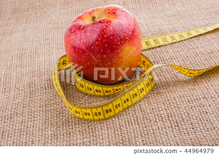 Red apple with a measurement tape on it Red apple with a measurement tape on it 44964979