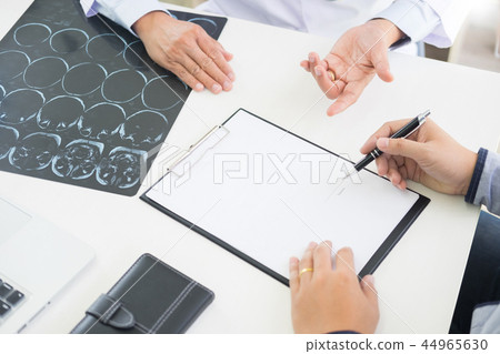 doctor giving a consultation discussing to patient and explainin doctor giving a consultation discussing to patient and explainin 44965630