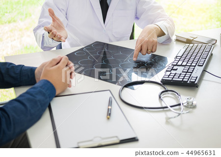 doctor analyzing a scan or x-ray film or explains a CT scan thou doctor analyzing a scan or x-ray film or explains a CT scan thou 44965631
