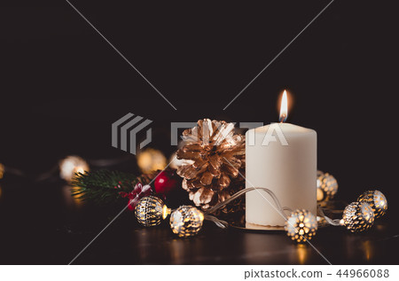 Christmas white candle with golden pine cone 44966088