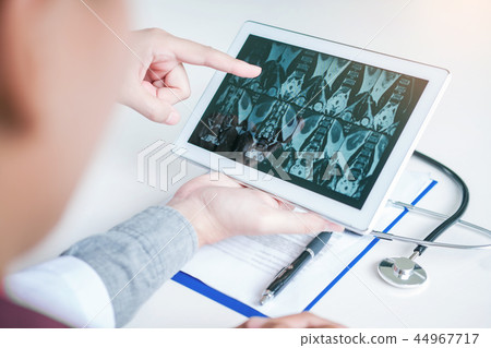 Doctor consulting with patient presenting x-ray Doctor consulting with patient presenting x-ray 44967717