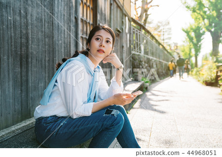 pretty lady sitting beside the street 44968051