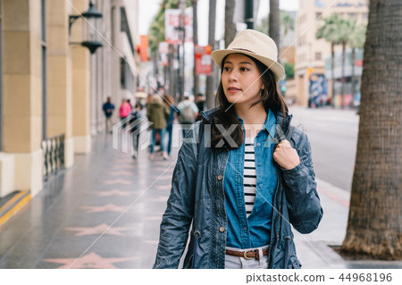 an elegant woman looking inside the show window 44968196