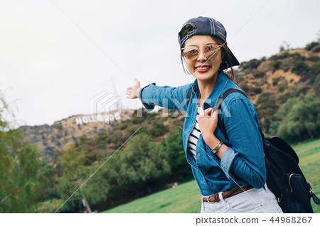 a joyful female hiker showing the Hollywood sign a joyful female hiker showing the Hollywood sign 44968267