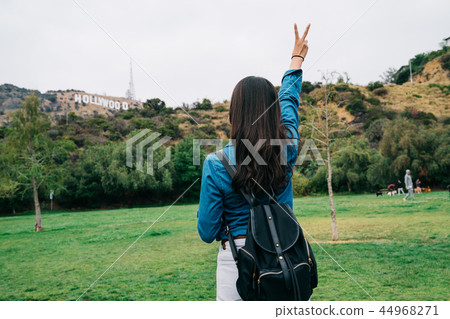 elegant female tourist showing victory sign 44968271