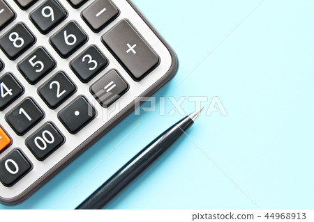 Calculator and pen on blue background Calculator and pen on blue background 44968913