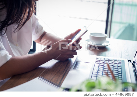 young woman is using smartphone and notebook young woman is using smartphone and notebook 44969097