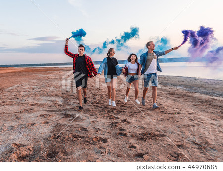 young friends running with hand flare or fusee 44970685
