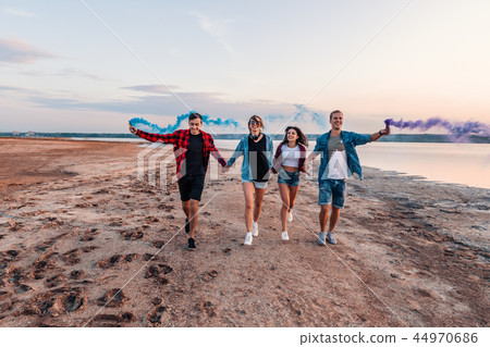 young friends running with hand flare or fusee 44970686