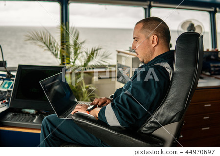 Marine navigational officer is using laptop or notebook at sea Marine navigational officer is using laptop or notebook at sea 44970697