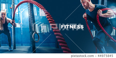 Men with battle rope battle ropes exercise in the fitness gym. 44973845