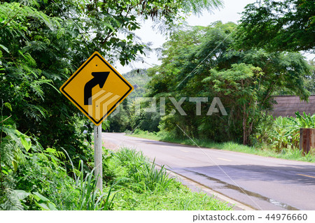 Warning turn right traffic sign in the countryside Warning turn right traffic sign in the countryside 44976660