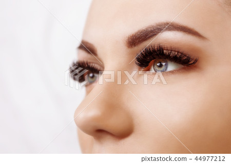 Eyelash Extension Procedure. Woman Eye with Long Eyelashes. Close up, selective focus. Hollywood Eyelash Extension Procedure. Woman Eye with Long Eyelashes. Close up, selective focus. Hollywood 44977212