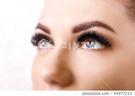 Eyelash Extension Procedure. Woman Eye with Long Eyelashes. Close up, selective focus. Hollywood 44977213