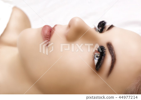 Eyelash Extension Procedure. Woman Eye with Long Eyelashes. Close up, selective focus. Hollywood Eyelash Extension Procedure. Woman Eye with Long Eyelashes. Close up, selective focus. Hollywood 44977214
