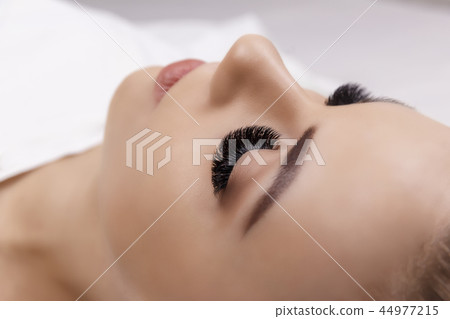 Eyelash Extension Procedure. Woman Eye with Long Eyelashes. Close up, selective focus. Hollywood Eyelash Extension Procedure. Woman Eye with Long Eyelashes. Close up, selective focus. Hollywood 44977215