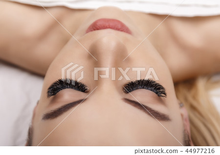 Eyelash Extension Procedure. Woman Eye with Long Eyelashes. Close up, selective focus. Hollywood Eyelash Extension Procedure. Woman Eye with Long Eyelashes. Close up, selective focus. Hollywood 44977216
