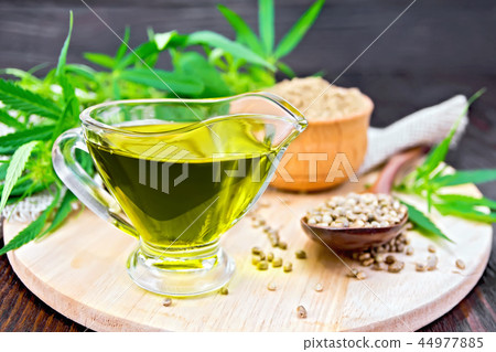 Oil hemp in sauceboat with grain on board Oil hemp in sauceboat with grain on board 44977885