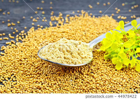 Mustard powder in spoon with flower on board 44978422