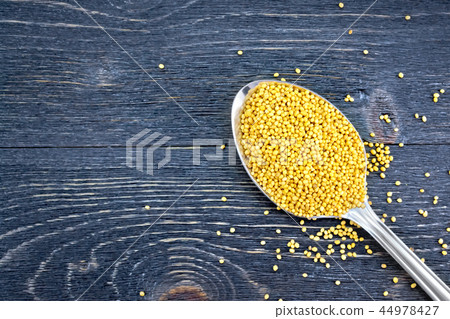 Mustard seeds in metal spoon on board top Mustard seeds in metal spoon on board top 44978427