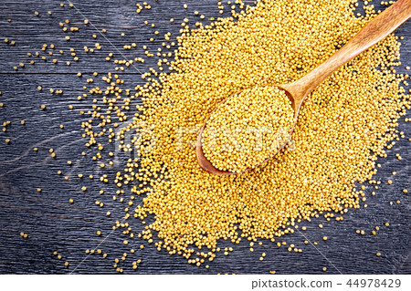 Mustard seeds in spoon on board top 44978429