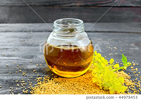 Oil mustard in jar with flower on board Oil mustard in jar with flower on board 44978453