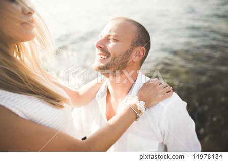 Just married wedding couple walking on the beach at sunset. Just married wedding couple walking on the beach at sunset. 44978484