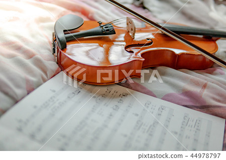 Violin and the sheet of music note on the bed 44978797