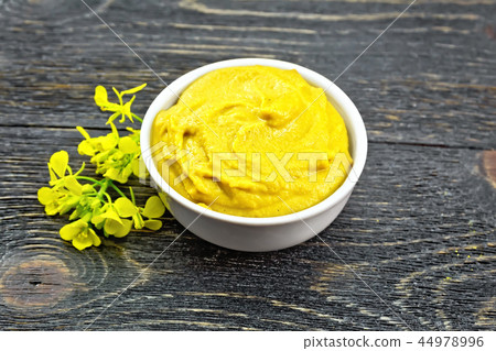 Sauce mustard in bowl with flower on black board Sauce mustard in bowl with flower on black board 44978996