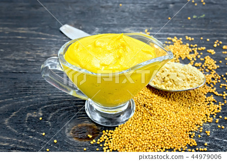 Sauce mustard in sauceboat with powder on board Sauce mustard in sauceboat with powder on board 44979006