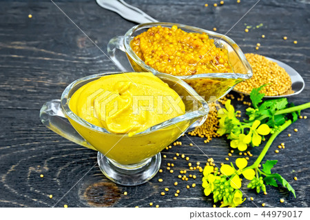 Sauce mustard in two sauceboats on wooden board 44979017