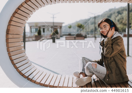 Joyful young woman enjoying best songs outdoors Joyful young woman enjoying best songs outdoors 44981615