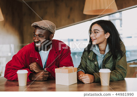 Smiling couple sitting in the cafe and looking into the distance Smiling couple sitting in the cafe and looking into the distance 44981990