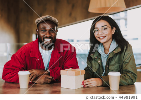 Delighted young people feeling happy while sitting with little present 44981991